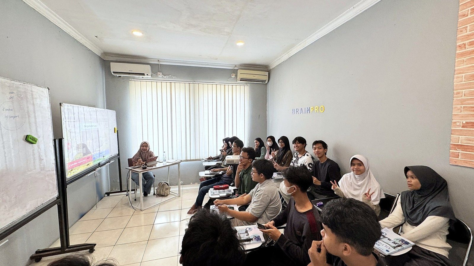 Kelas penuh peserta BrainPro menghadap pengajar dan layar